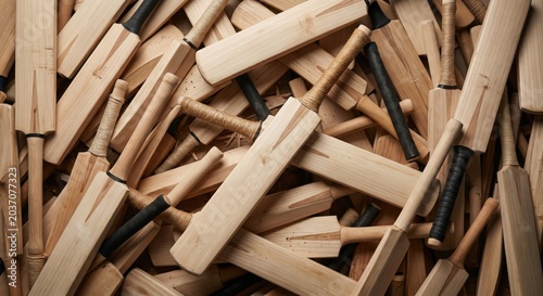 Abundant collection of handcrafted wooden cricket bats stacked together in a professional workshop setting highlighting traditional sports equipment manufacturing craft