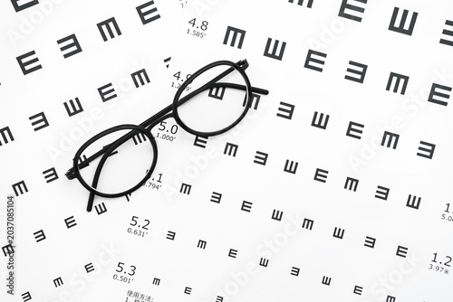 Schilderij op canvas Eyeglasses and visual acuity chart in white background