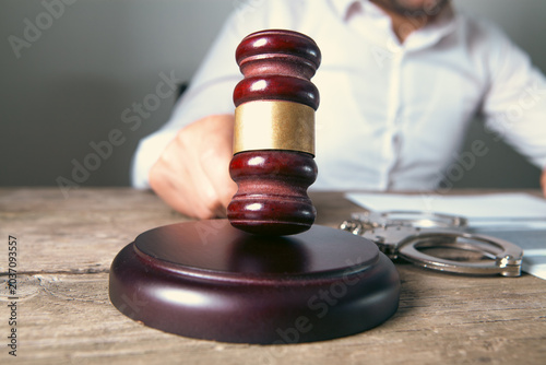 lawyer gavel and handcuffs on table in courtroom or law firm