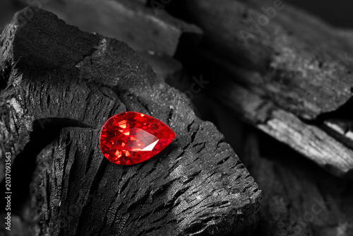 Red Ruby gemstone on black coal background, close up shot