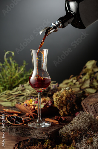 Canvastavla Herbal bitter liqueur is poured from a vintage bottle into a glass
