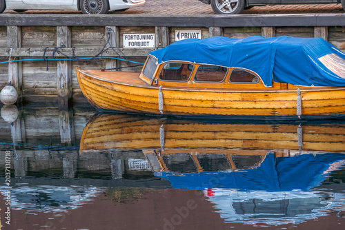 Traditional Danish Wooden Motorboat Moored by a Wooden Pier, Water Reflection Concept, Copenhagen