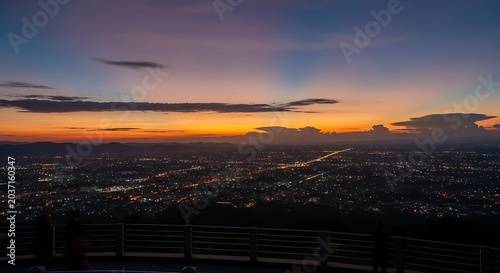 Aerial view of glowing city lights at sunset from an observation deck