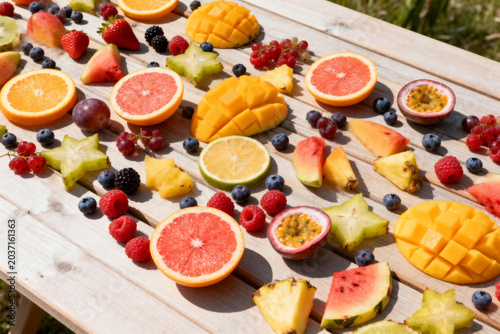 Assorted fresh tropical fruits sliced and arranged on wooden table