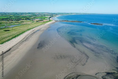 Aerial drone view of Ballynamona Strand on the East Cork coastline in Ireland, featuring sandy beach, coastal dunes, tidal flats and scenic Atlantic shoreline near Ballycotton