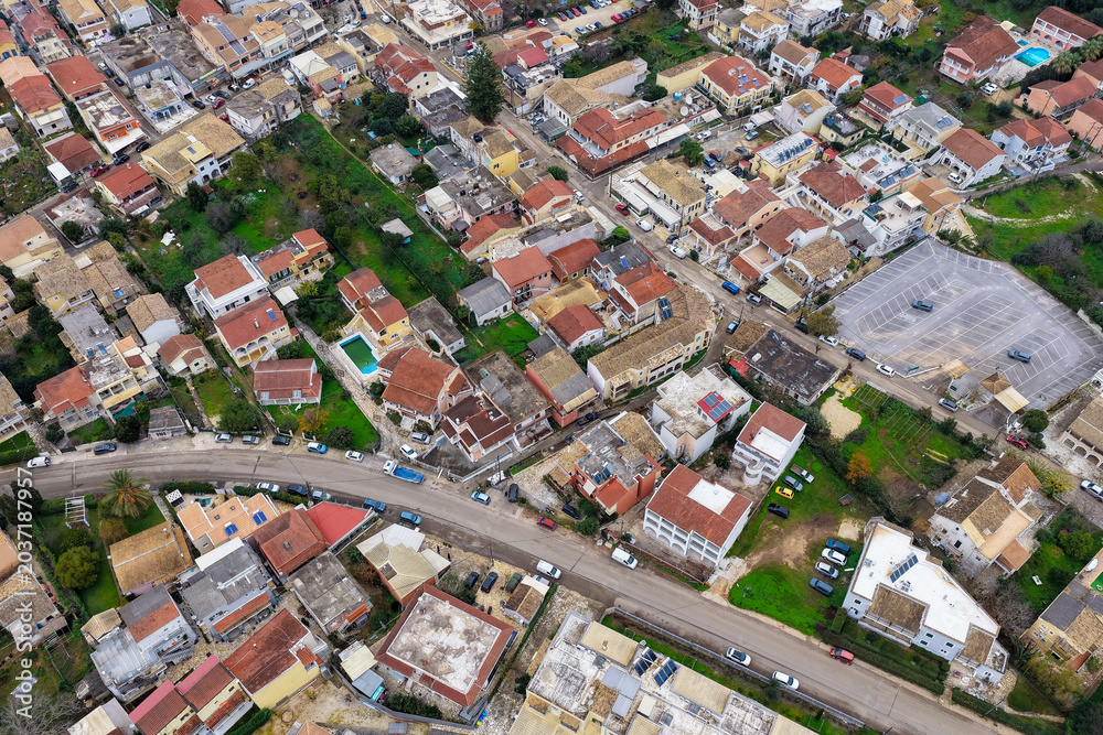 Fototapeta premium High Angle Aerial Drone View of Kassiopi Town Streets Parking and Red Rooftops on Corfu Island Greece