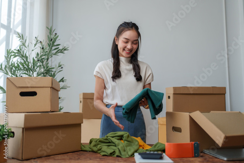 Young woman packing clothes for online dropping shipping business