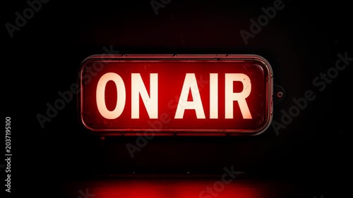 Bright red on air sign glowing in dark studio for broadcasting and live streaming concept