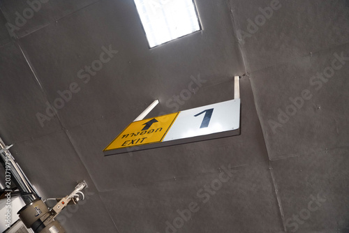 Exit 1 sign with arrow on ceiling at a public transit station in Thailand