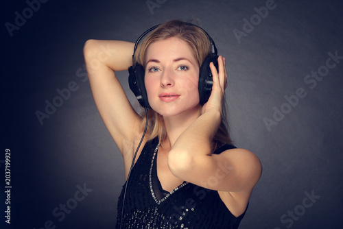 Young woman listening to music on headphones smiling