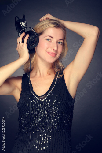 Young woman listening to music on headphones smiling