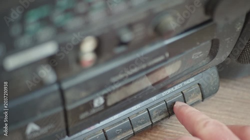 Nostalgic 90s analog electronics covered in heavy dust, pressing buttons on an obsolete cassette recorder.