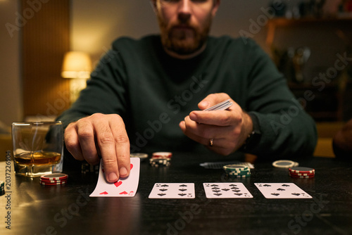 Obraz na płótnie Caucasian young adult men playing poker, revealing cards and betting with chips, expressing male friendship and leisure bonding