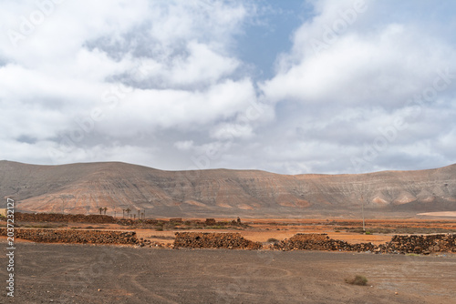 Photos Fuerteventura volcanic desert with dry stone walls in foreground, rocky valley s
