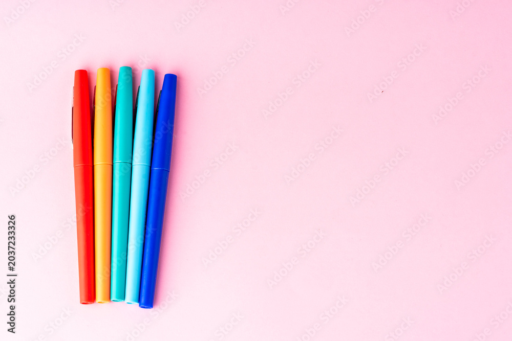 Fototapeta premium coloured rainbow pens on a pink background