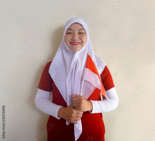 Beautiful Asian Muslim Girl Holding Indonesia Flag And Smiling At Camera