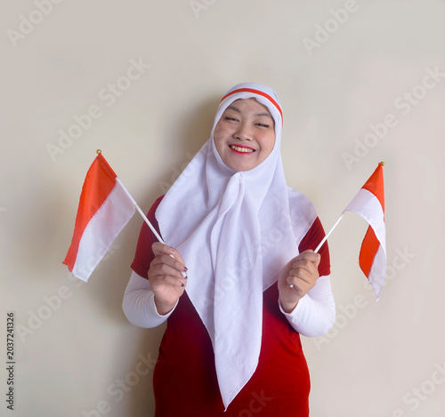 Young Girl Holding Two Little Flag With Both Hands To Shows Support For Her Football Team Or Celebrating Indonesia Independence Day