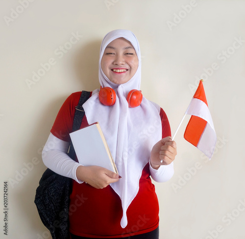 Young College Girl Wear Hijab And Headphones On Neck Holding National Flag Shows Support For Her Football Team