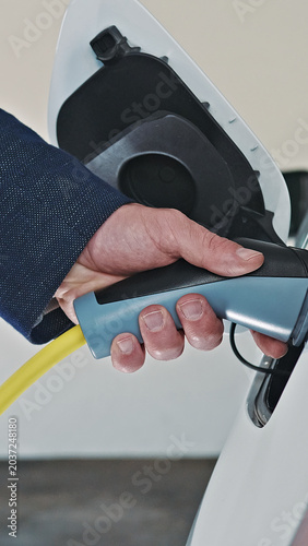Konstfotografi A person is charging an electric vehicle at a station