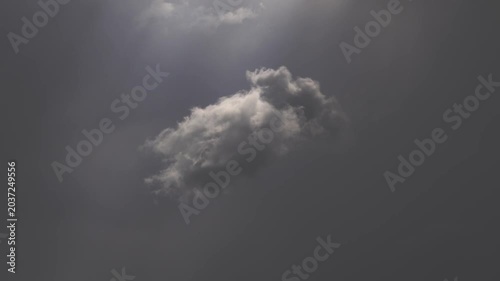 Wind dissolving cloud against gray overcast sky background.