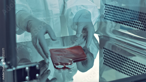 Foto In a sterile laboratory, a researcher in a clean suit carefully handles a blood sample, emphasizing precision and safety in medical research