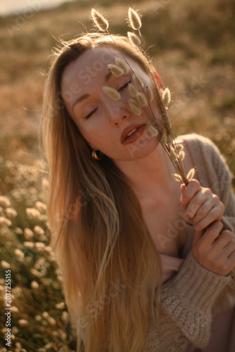 Close up portrait of blonde Slavic girl with dried flowers near face, natural skincare, self care and soft beauty aesthetic, fresh natural skin and feminine calm concept