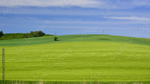 A calm spring morning with green hills and a blue sky in Transylvania.