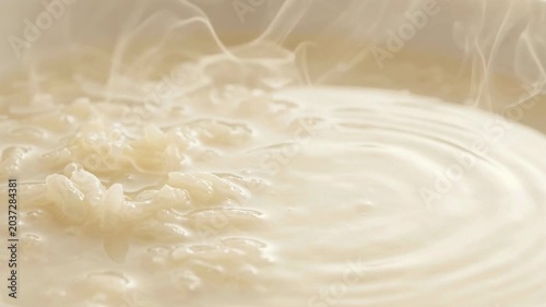 Close-up view of steaming rice cooking in a pot with water, creating a serene cooking atmosphere