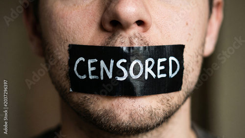 Close-up of tape on a human mouth with the word Censored, symbolizing the suppression of speech, silence, and social ostracism associated with mental health struggles and the advocacy for free speech