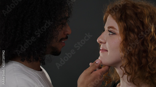 Bild auf Leinwand Man tenderly touching woman's chin showing connection and relationship