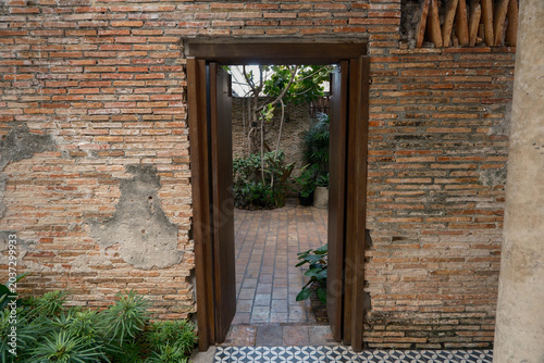 Rustic wooden door frame with historic orange brick wall architecture