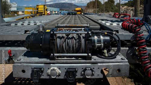 Fotografie Close up view of electric winch on car hauler truck trailer with steel cable rea