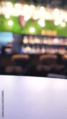 Close-up of a woman's hand at a bar, taking a glass of drink.