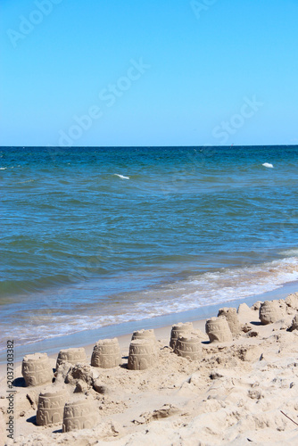 Sandcastles on the Baltic Sea beach under clear blue sky. Travel concept
