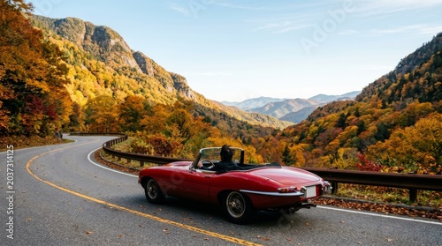 Red Convertible Sports Car Driving on Winding Mountain Road in Autumn