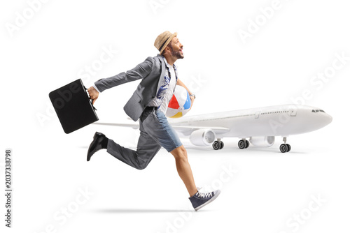Obraz na płótnie Man dressed half as businessman half as a tourist running to catch a plane