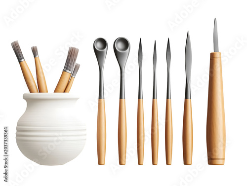 Collection of artist's tools, including brushes in a pot and various sculpting instruments, neatly arranged on a clean surface, showcasing creative essentials for art and craft projects