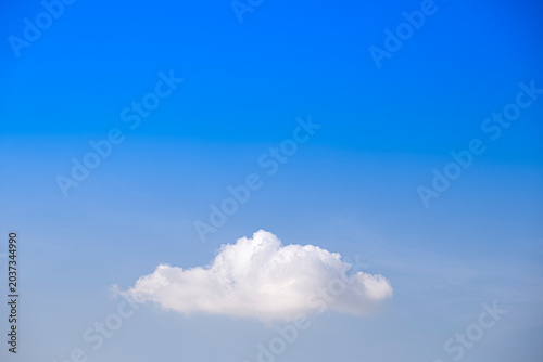 A Single Fluffy White Cloud In Blue Sky