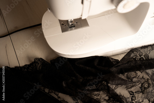Принти на полотні top-close view of a white domestic sewing machine on a pale wooden floor, warm s