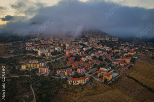Sunrise view of the rooftops of Gangi with morning fog. Sicily, Italy. August 2024. Aerial drone picture.