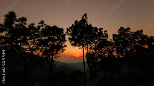 Cuadro en lienzo warm yellow orange sunset in the mountains forming a silhouette of the trees and