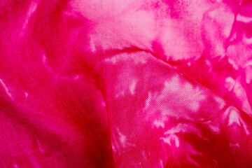 Close up of tie dye fabric with pink and white colors
