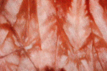 Macro view of tie dye fabric with red and white abstract design