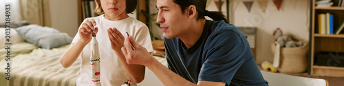 Header of Asian father and child son assembling model rocket together at home, learning engineering skills and teamwork. Useful for parenting, STEM education, family bonding campaigns