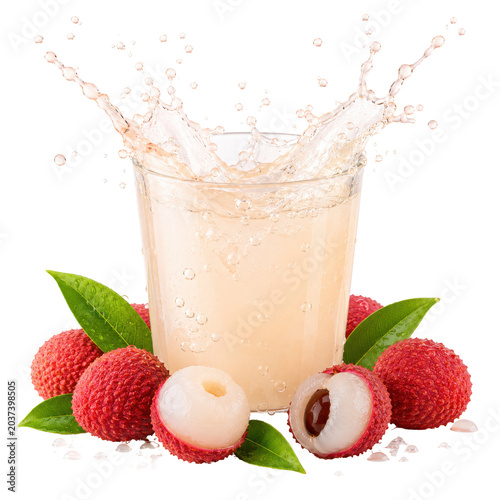 Litchi juice splashes into a glass surrounded by fresh litchis and green leaves on a table.