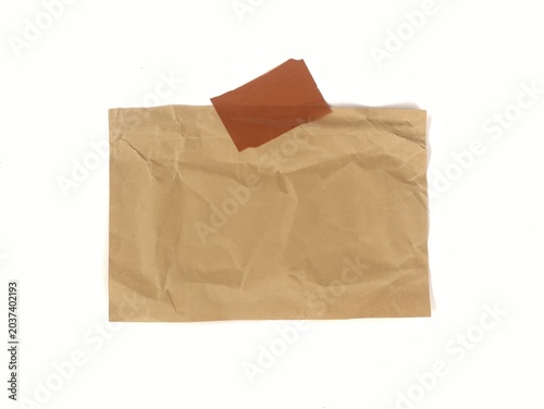 Crumpled brown paper note with adhesive tape isolated on white background, providing an empty space or template for design and text
