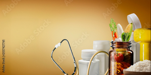 Fotografie Bottles of vitamins, health supplements for nutrient deficiencies, and lifestyle supplements for a balanced diet are displayed against a yellow background