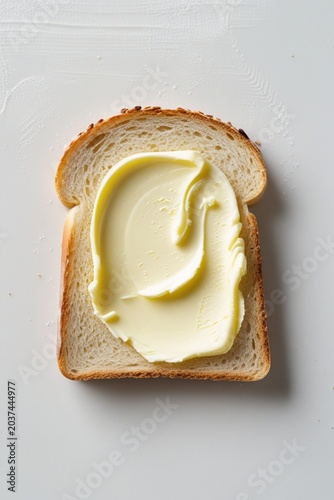 Slice of bread with creamy butter spread, simple breakfast food isolated on clean white background