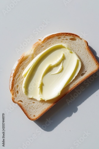 Slice of bread with creamy butter spread, simple breakfast food isolated on clean white background