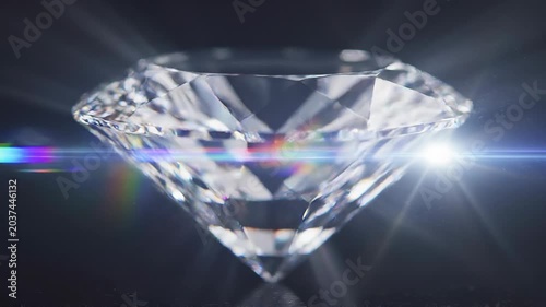 Close up of sparkling diamond reflecting light with rainbow prism effect on dark background